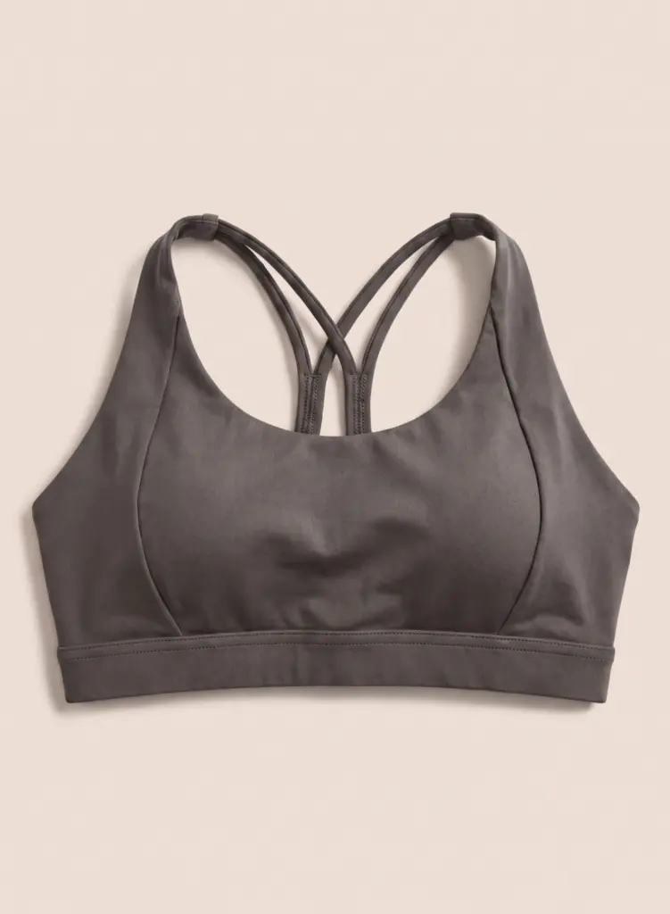 Vauxelle charcoal gray sports bra front flat lay on warm cream background
